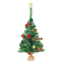 A 2ft green pre-lit artificial Christmas tree with red baubles, gold ornaments, pine cones, bows, and a star topper on a burlap base.