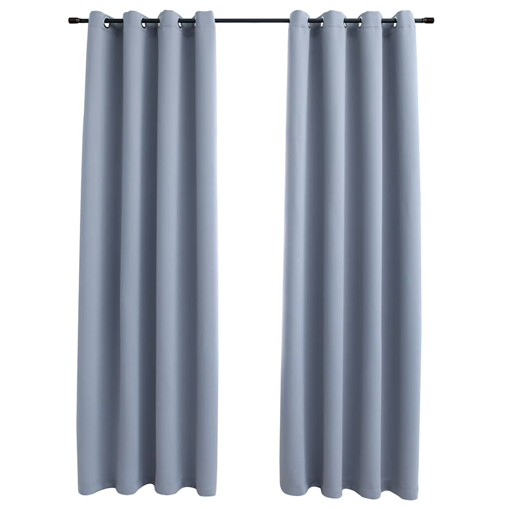 Two gray blackout curtain panels with rings hang on a rod.
