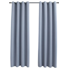 Two gray blackout curtain panels with rings hang on a rod.