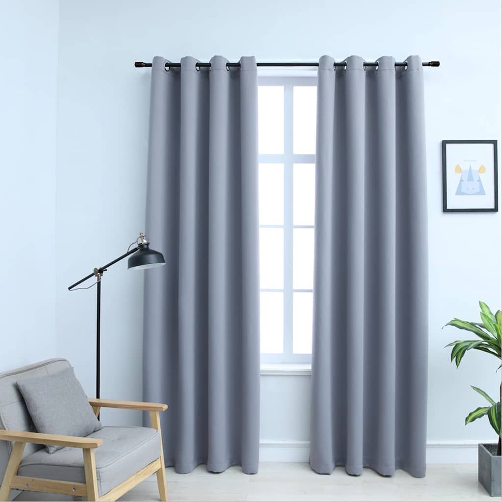 Two gray blackout curtain panels, 54x84 inches each, with rings, hanging on a window.