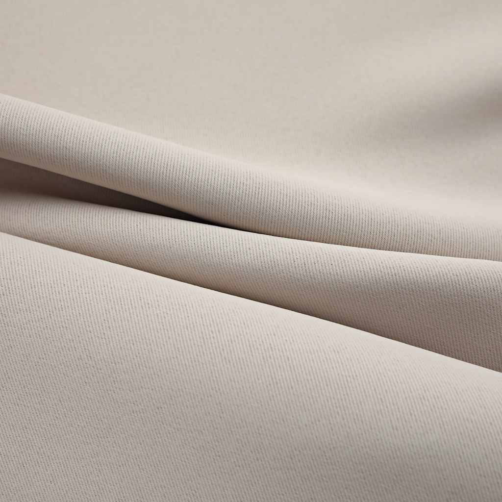 Close-up of beige blackout curtain fabric with subtle folds and texture.