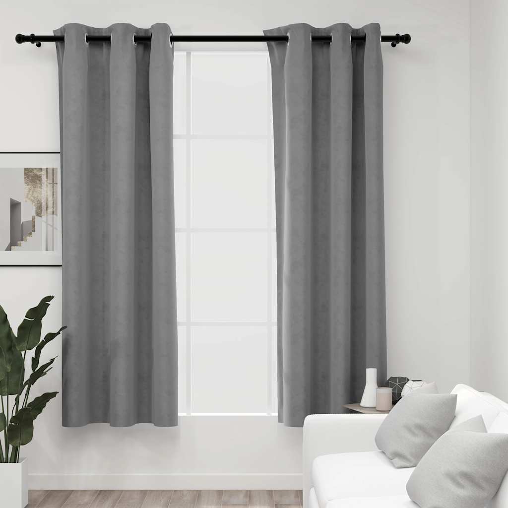 Gray velvet blackout curtains with rings on a window in a modern living room.