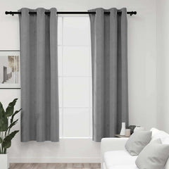 Gray velvet blackout curtains with rings on a window in a modern living room.