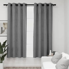 Gray velvet blackout curtains with rings hung on a window in a modern living room.
