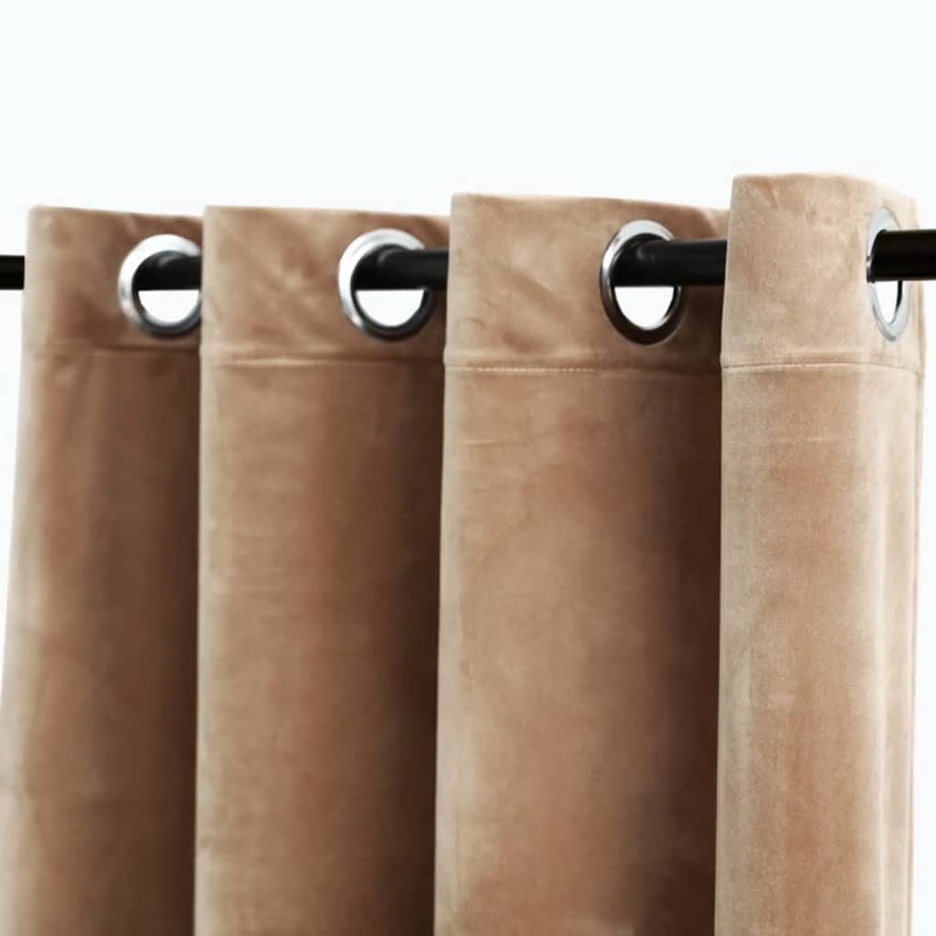 Beige velvet blackout curtains with grommet rings on a rod, shown as a pair.