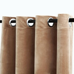 Beige velvet blackout curtains with grommet rings on a rod, shown as a pair.