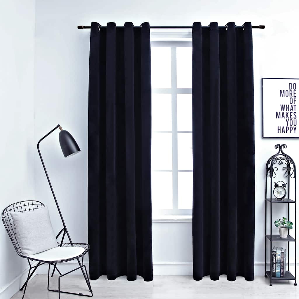 Two black velvet blackout curtain panels, 54x63 inches, hung on a rod with rings in a modern room.
