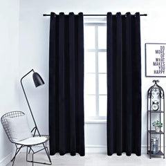 Two black velvet blackout curtain panels, 54x63 inches, hung on a rod with rings in a modern room.