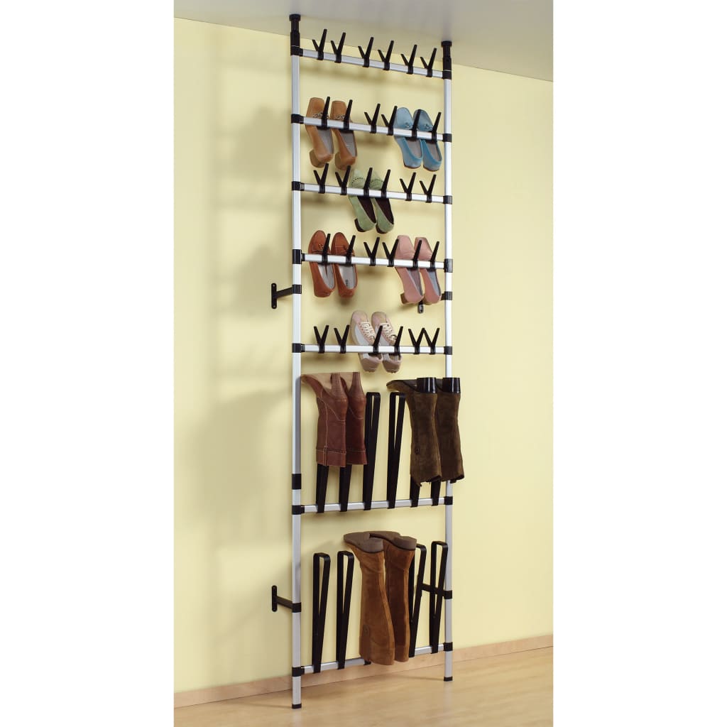 Silver telescopic aluminum shoe rack mounted on wall, holding various shoes and boots on rods.