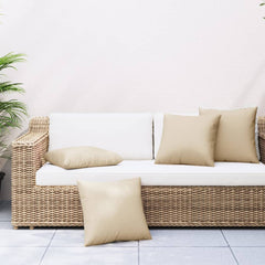 Four beige square polyester throw pillows measuring 23.6 by 23.6 inches on a wicker sofa.
