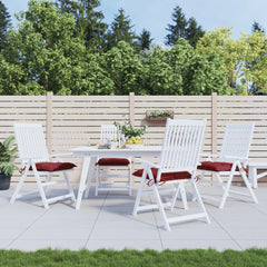 Four wine red Oxford fabric chair cushions with red ties on white patio chairs.