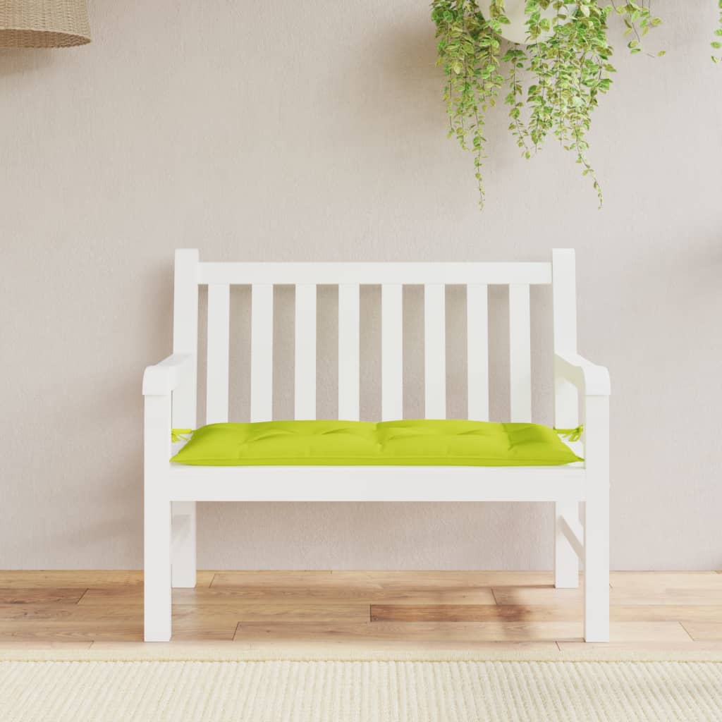 A bright green garden bench cushion is centered on a white slatted bench.