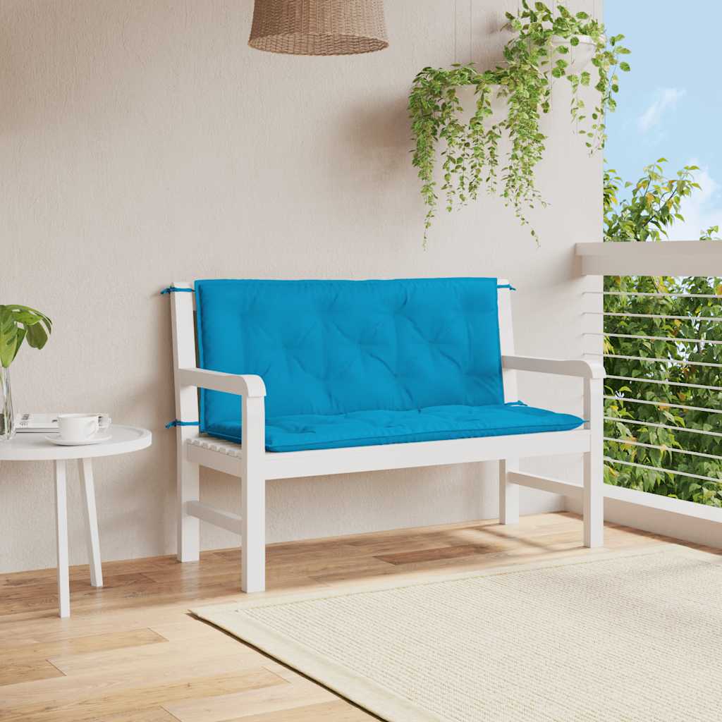 A light blue garden bench cushion is tied to a white wooden bench on a patio.