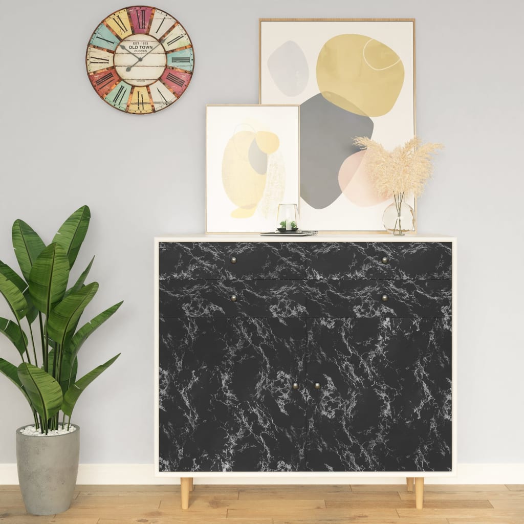 A modern room with a black marble-effect cabinet, colorful wall clock, abstract art, potted plant, and vase.