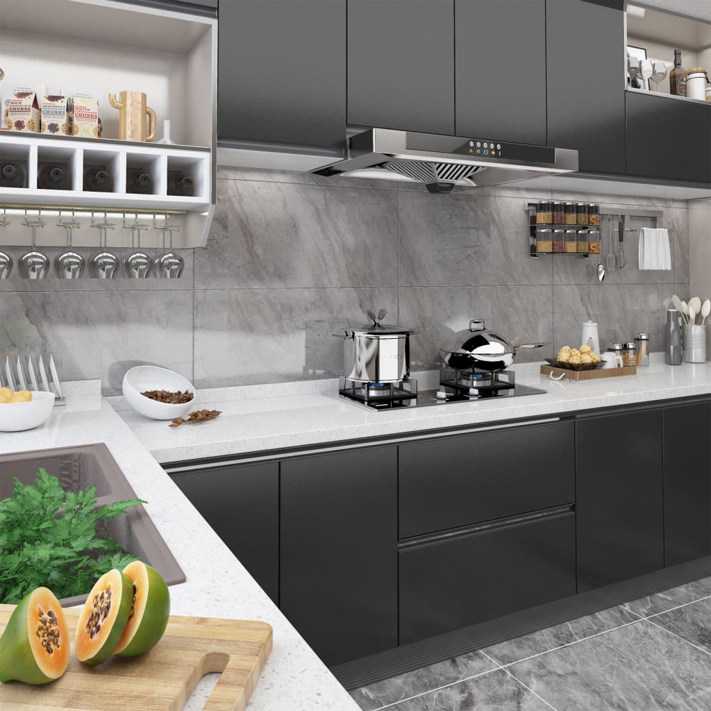 Modern black kitchen with glossy cabinets, stainless appliances, and white countertop.
