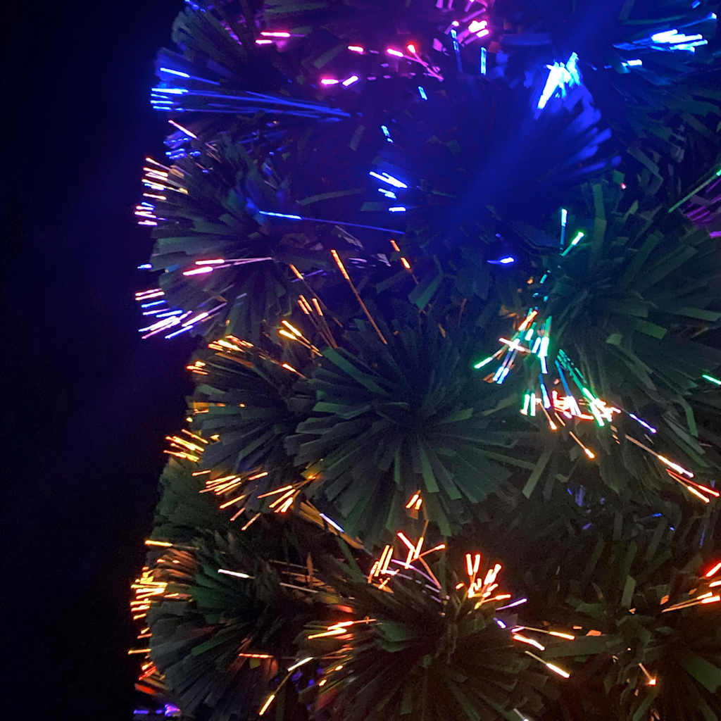 A close-up of a fiber optic Christmas tree with colorful lights.