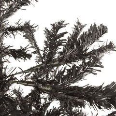 Close-up of the dark black artificial Christmas tree branches against a white background.