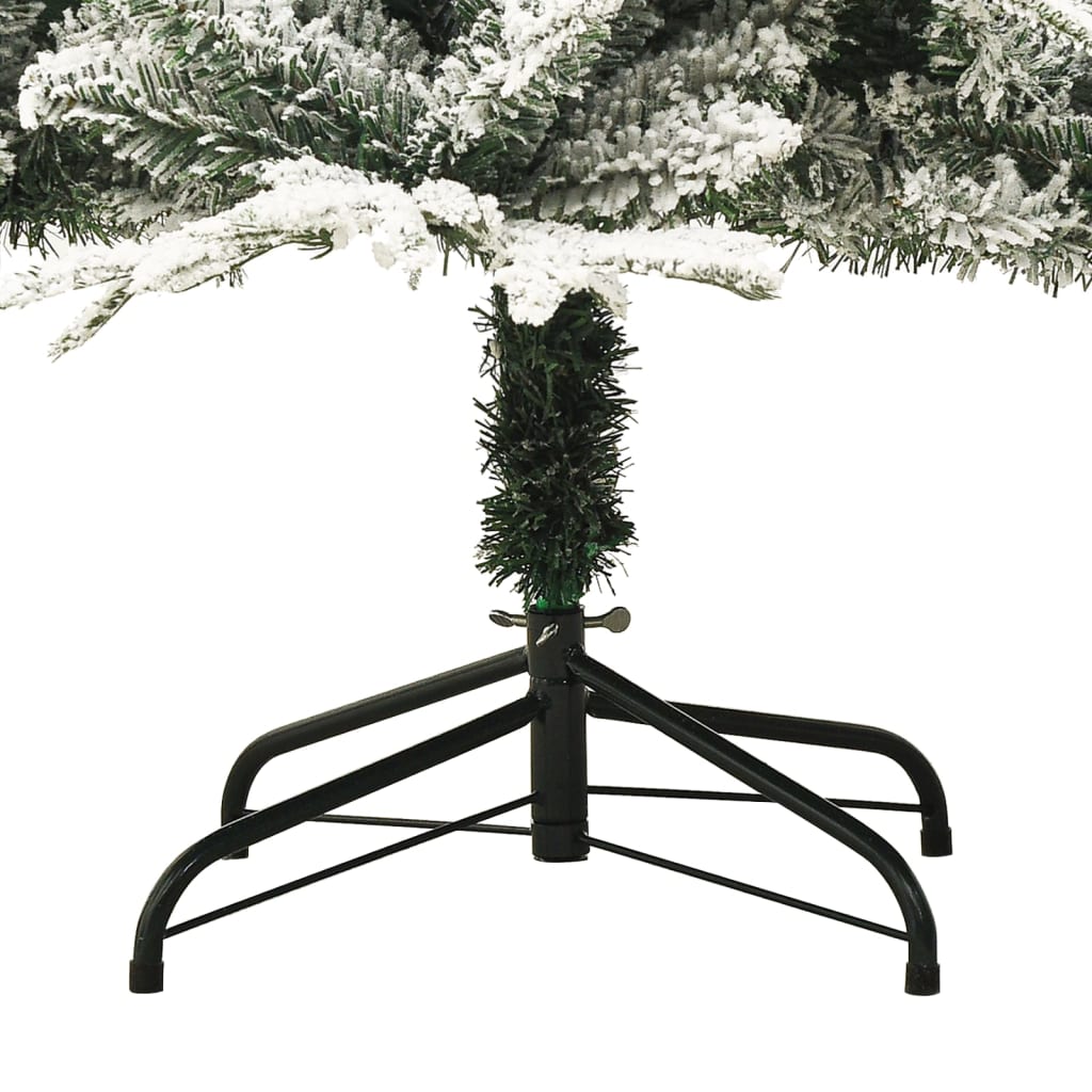 Black metal stand supporting a green artificial Christmas tree with flocked snow on branches