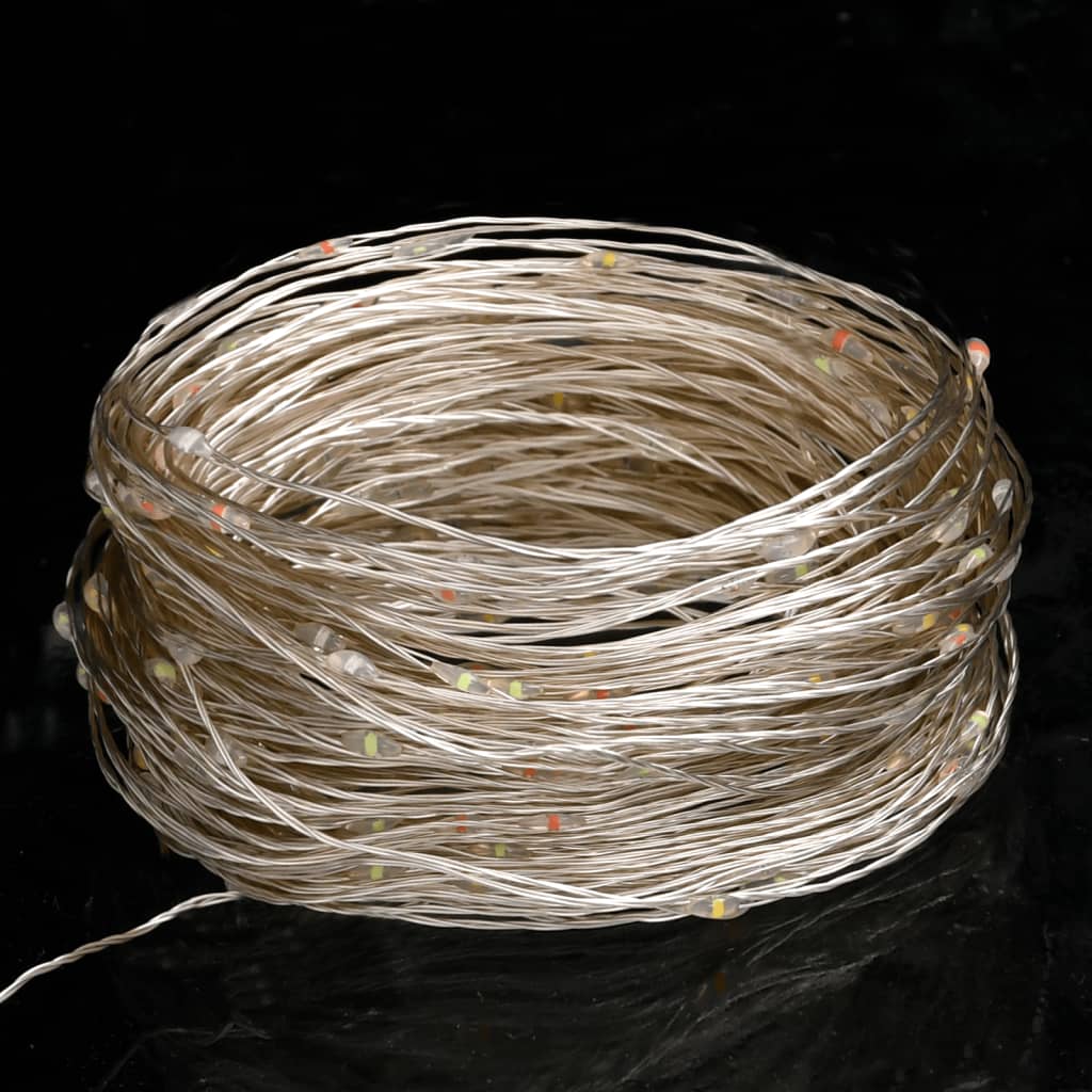 A coiled bundle of multicolor LED string lights on a dark surface.