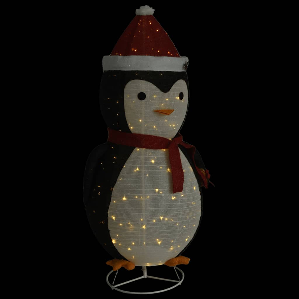 A lighted penguin figure wearing a red Santa hat and scarf.