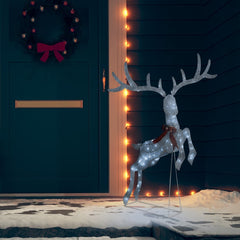 A white LED flying reindeer Christmas decoration stands on a snowy porch.