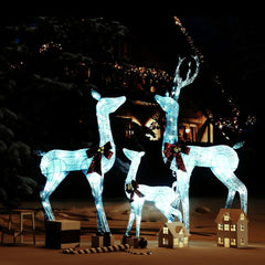 White LED-lit reindeer family Christmas decoration with silver accents and red bows.
