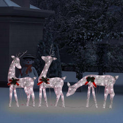 Three lighted gold reindeer with red bows and warm white LEDs stand in a snowy scene.