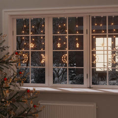 Bostome 138 LED warm white star and moon fairy lights with remote, shown hanging in a window.