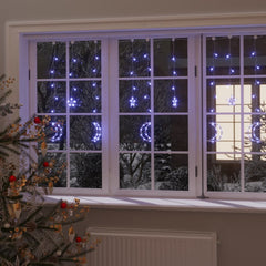 Blue star and moon fairy lights with 138 LEDs on a curtain, illuminating a window.