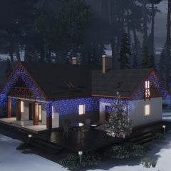 Blue LED curtain icicle lights draped on a snowy house with trees at night.