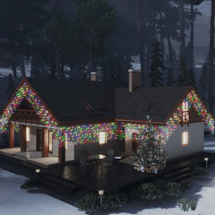 House decorated with colorful LED curtain icicle lights and a lit Christmas tree outside at night.