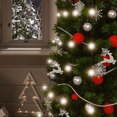 Festive Christmas tree with white and red ornaments, lit by cold white fairy lights, beside a snowy window.