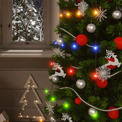 A 5-pack of colorful 200-LED solar fairy lights strung on a decorated Christmas tree with snowy window view.
