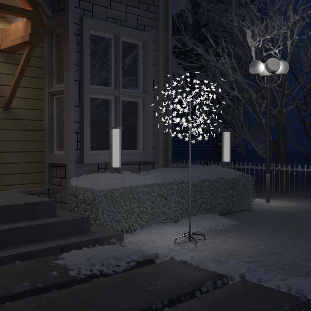 A 6 ft cherry blossom Christmas tree with 200 cold white LEDs stands in a snowy outdoor scene at night.