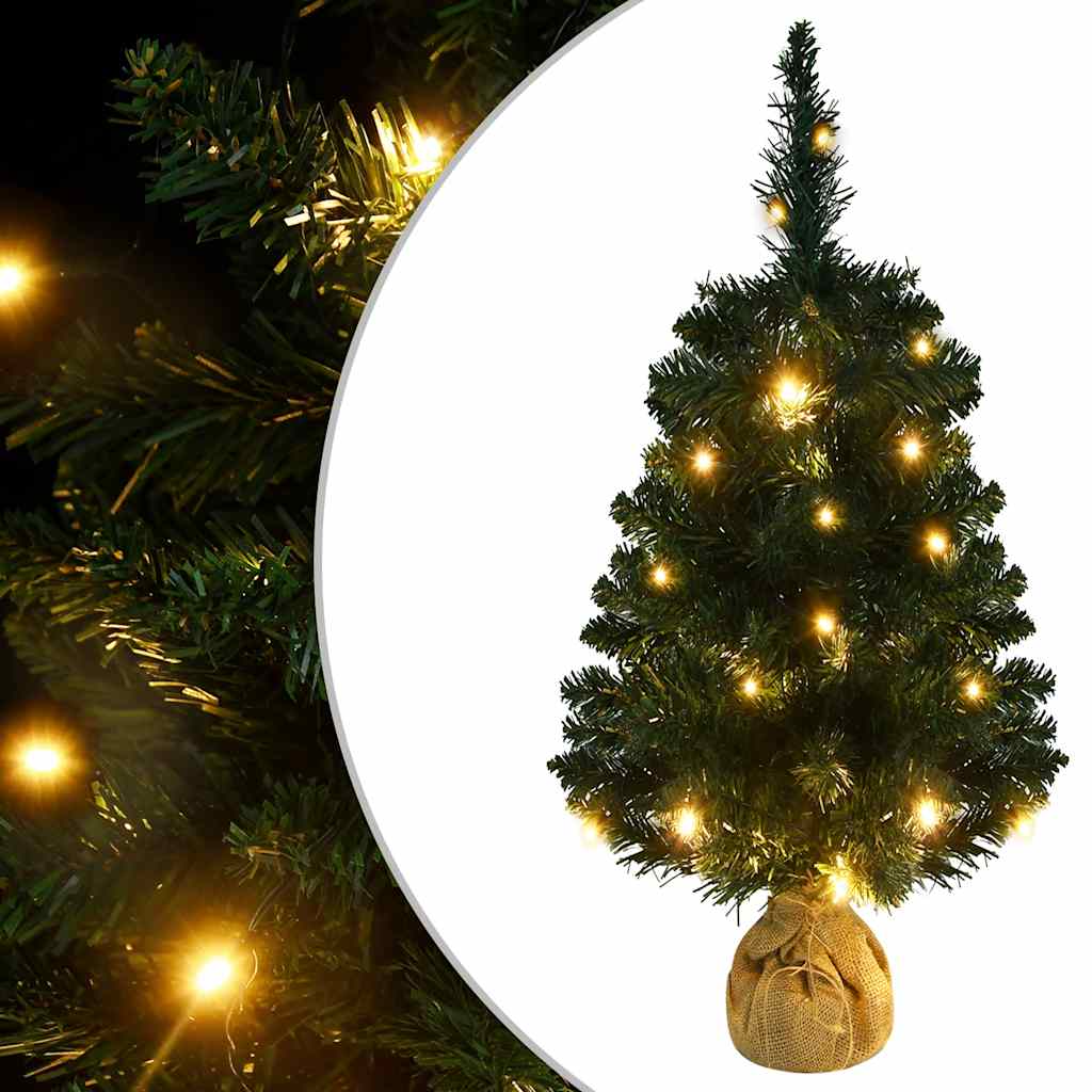 A 3 ft pre-lit artificial Christmas tree with green PVC branches and warm LED lights on a linen-wrapped stand.