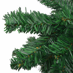 Close-up of green artificial Christmas tree branches with dense PVC needles