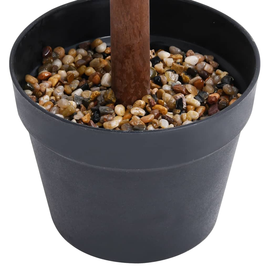 A dark gray pot holds a brown stem surrounded by small, colorful pebbles.