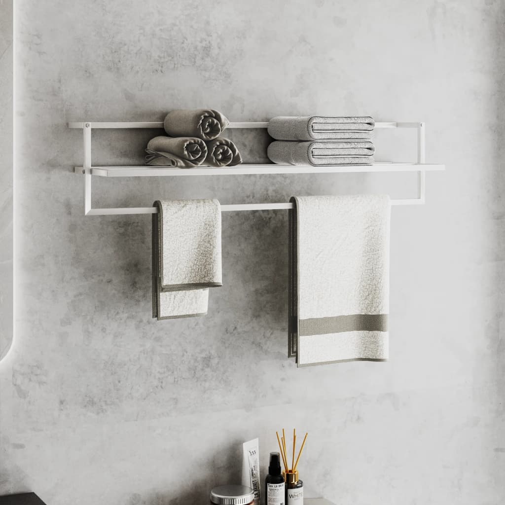White wall-mounted iron towel rack with shelf holding rolled towels and hanging towels.