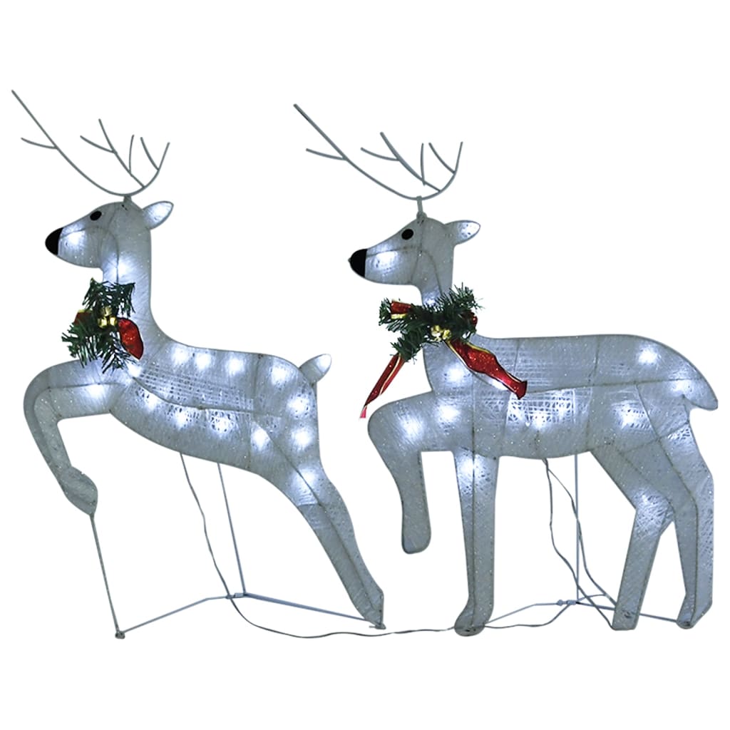 Two lit white reindeer with red bows and holly, part of a 100-LED outdoor Christmas decoration set.