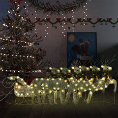 Golden reindeer and sleigh Christmas decoration with 140 LEDs, lit up outdoors near a tree.