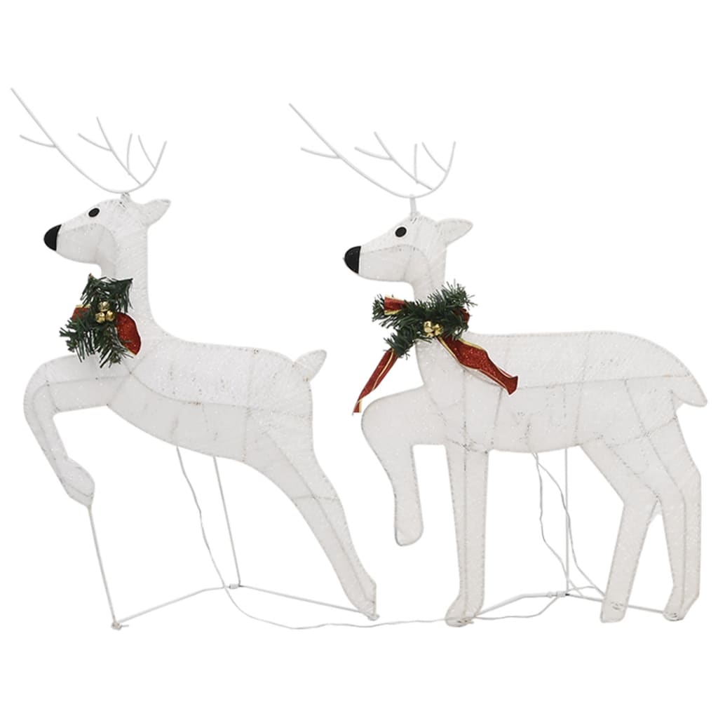 White LED-lit reindeer and sleigh outdoor Christmas decoration with red bows and greenery.