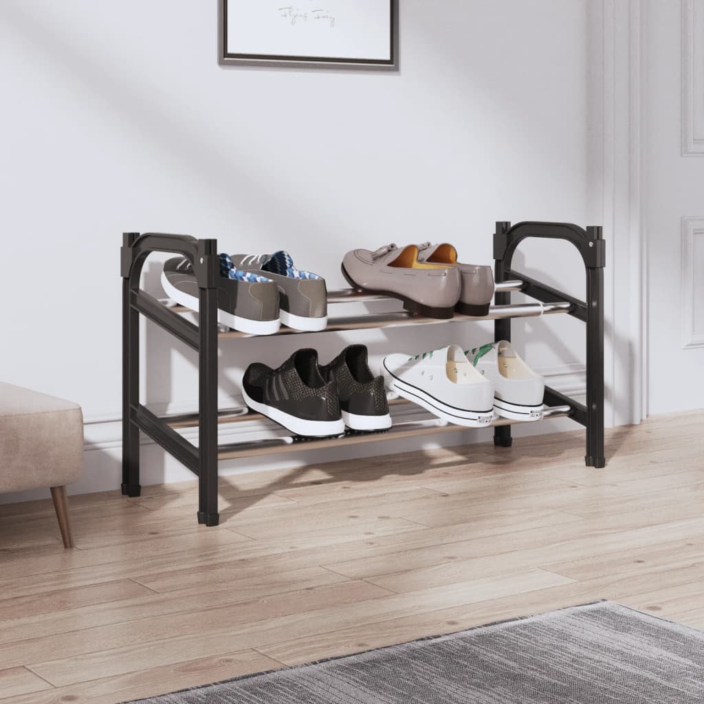 Black and silver extendable aluminum shoe rack with two shelves holding various shoes in an entryway.