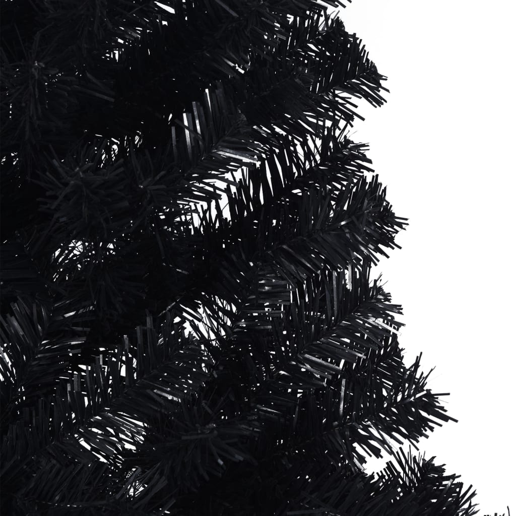 A close-up of a black artificial Christmas tree with dense PVC needles.