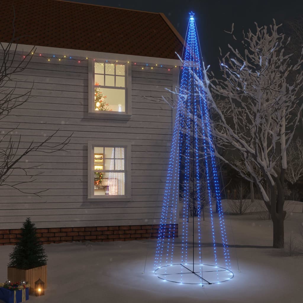 A tall blue LED Christmas cone tree with 1134 lights stands lit up in a snowy yard at night.