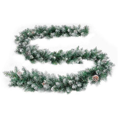 A 9 ft green PVC Christmas garland with flocked tips, pine cones, and warm white LED lights.