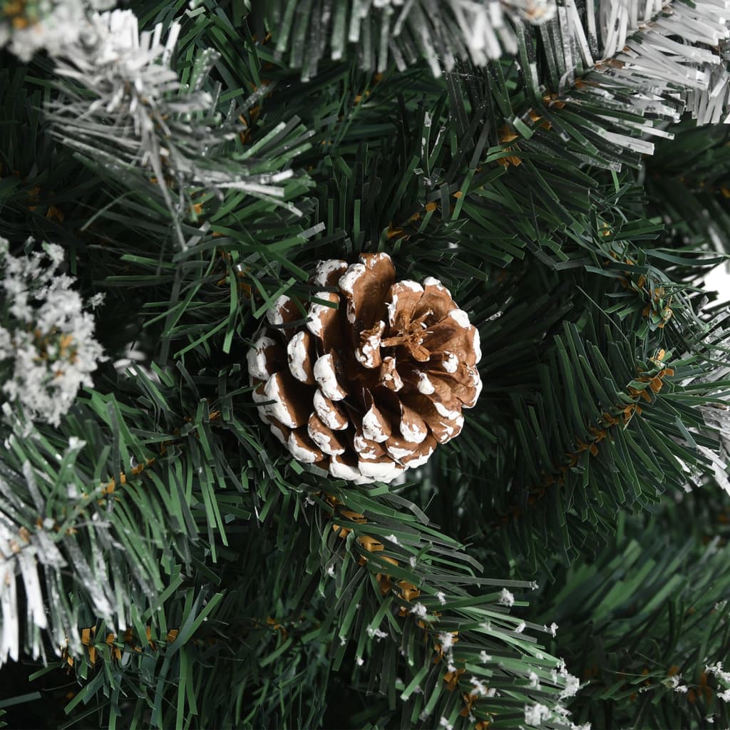 Green artificial Christmas tree with snow, glitter, natural cones, and a sturdy stand.