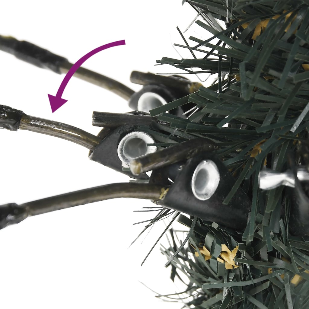Close-up of hinged branches on a green artificial Christmas tree with PVC needles and cones.
