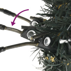 Close-up of artificial Christmas tree base showing hinged branches and stand assembly.