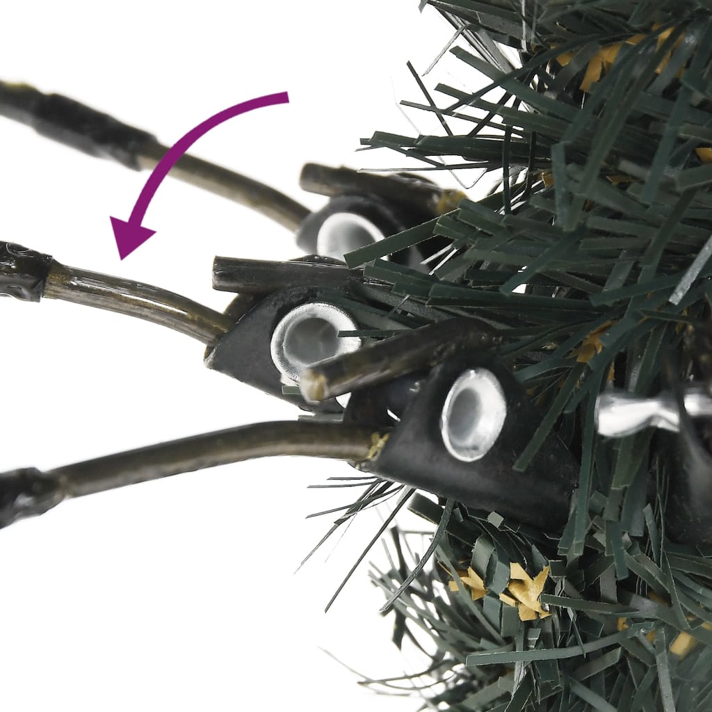 Close-up of hinged branches on a 7ft green artificial Christmas tree with snow.
