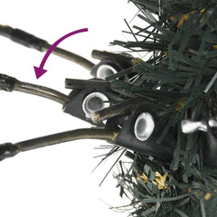 Close-up of hinged branches on a 7ft green artificial Christmas tree with snow.